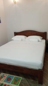 Kuala PenyuMargereth Cottage的一张带白色床单和枕头的床