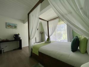 锡拉奥La Villa Soalic的一间卧室配有一张天蓬床和窗户