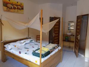 姆布尔Guesthouse Dalal ak Jàmm的一间卧室配有一张带蚊帐的床
