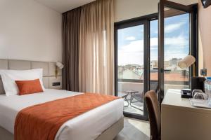 里斯本Empire Marquês Hotel的酒店客房设有床和窗户。