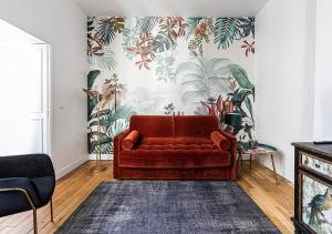 巴黎123paris city的客厅里一张红色的沙发,墙上挂着一扇