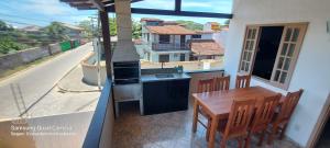 布希奥斯Casa das Conchas Búzios的厨房配有炉灶,阳台上配有桌子
