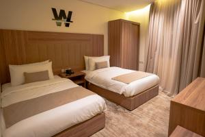 艾卜哈W Suites Hotel的一间酒店客房,房间内设有两张床