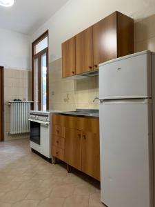 拉卡莱Casa Della Nonna的厨房配有白色冰箱和木制橱柜。
