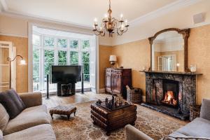 柯比朗斯代尔The Casterton Grange Estate的客厅设有壁炉和电视。