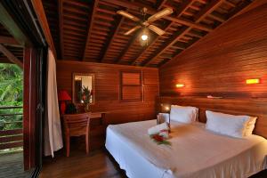 巴斯特尔马兰加花园酒店的一间卧室配有一张带吊扇的床和一张书桌。