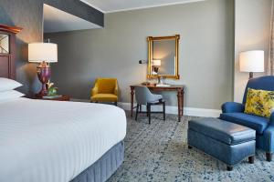 莫比尔贝特豪斯万丽移动酒店&Spa的酒店客房配有一张床、一把椅子和一张书桌