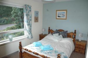 布罗德福德Dunmara: Self Catering Cottage on the Isle of Skye的一间卧室配有一张带蓝色毛巾的床