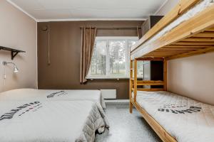 Lärbro莱尔布鲁/格兰内恩STF旅馆的一间卧室设有两张双层床和一扇窗户。