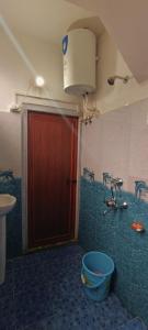 大吉岭SILENT AM HOMESTAY的一间带红色门和水槽的浴室