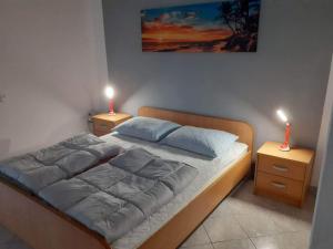 拉布Apartments Felicce的一间卧室配有一张带两盏灯的床。