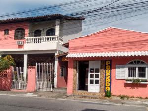圣佩德罗-达阿尔德亚Pousada Sol de Verão的街道边的粉红色建筑
