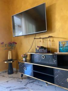 巴韦诺Appartamento feriolo Margherita的墙上的电视机,带蓝色梳妆台