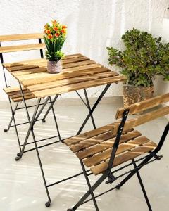 贝尔谢巴Pninat Hadrom的一张木桌和一张带鲜花的椅子