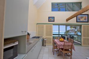 拉罗汤加白沙滩别墅的一个带桌子并享有海景的厨房