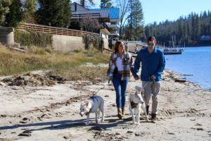 巴斯莱克松之林度假酒店及会议中心的一名男子和女子在海滩上行走两只狗