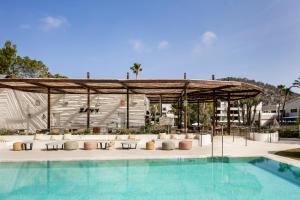 圣蓬萨Kimpton Aysla Mallorca, an IHG Hotel的游泳池设有凉亭、椅子和游泳池