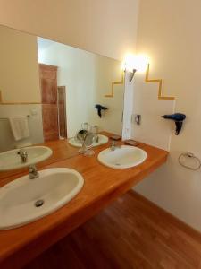 圣阿非力克多马内德拉斯果斯酒店的一间带两个盥洗盆和大镜子的浴室