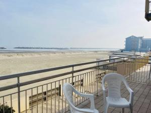 丽都迪萨维奥Hotel Lima的两把椅子坐在俯瞰海滩的阳台上