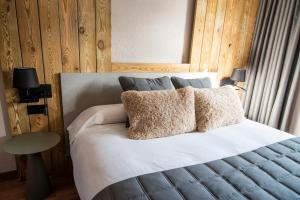 圣胡利娅-德洛里亚Borda Conangle Mountain Lodge的一间卧室配有带白色床单和枕头的床。