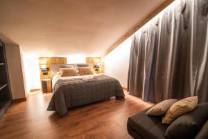 圣胡利娅-德洛里亚Borda Conangle Mountain Lodge的一间卧室配有一张床和一张沙发