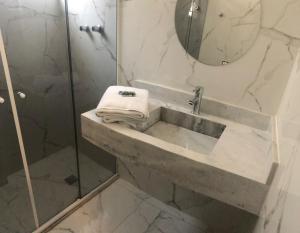 桑托斯Gonzaga Flat的带淋浴和盥洗盆及镜子的浴室