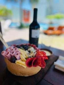 特尔马斯德里奥翁多Hotel Termal Emperatriz的桌上的水果蛋糕和一瓶葡萄酒