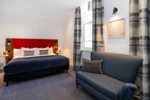布里斯托布里斯托尔伯克利广场酒店的一间卧室配有一张床、一张沙发和一把椅子