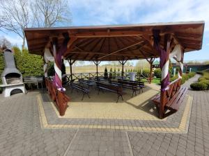SierpcHotel Ambrozja的公园内带桌子和长凳的凉亭