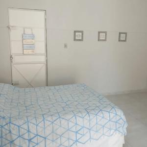 沃尔塔雷东达Edícula no centro de VR的一间卧室配有一张带蓝色和白色棉被的床