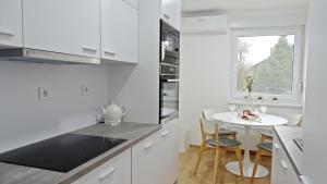 科普里夫尼察Apartment No15的白色的厨房,配有小桌子和窗户