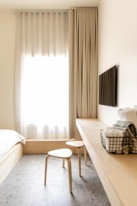 Havre-AubertPetit hôtel de la Montagne的一间卧室配有一张床、一张桌子和一台电视。