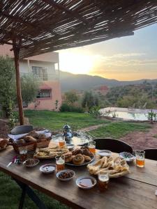 OuzoudDar Khalti - Cascades - Piscine - Montagne的一张野餐桌,上面有食物和饮料