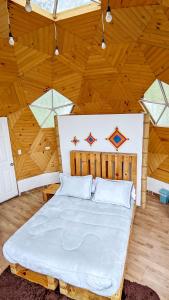 拉维加Glamping Reserva del Roble的卧室设有一张木制天花板上的大床