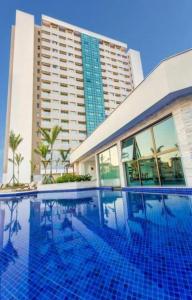 里约热内卢Flat Hotel Samba Barra Jeunesse Arena Projac Rio Centro的一座大建筑前的游泳池