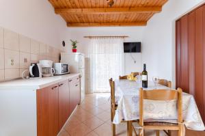 洛帕Apartment Marija Durdica的厨房配有桌子和白色冰箱。