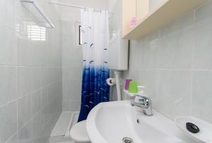 苏佩塔斯卡德拉加Apartments Katica的浴室设有白色水槽和蓝色的浴帘