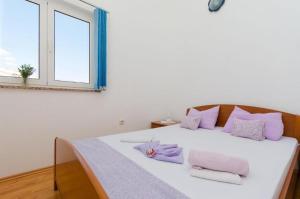 普纳特克鲁诺斯拉夫公寓的白色的床、紫色枕头和窗户