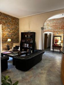 佛罗伦萨贝坦尼亚别墅酒店的客厅配有黑色沙发和砖墙