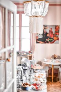比亚里茨Maison Garnier Hôtel de Charme Biarritz的餐桌,带食物盘和吊灯