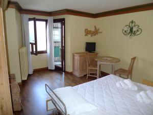 摩德纳迪-坎皮格里奥RTA卡杜拉尼酒店的卧室配有白色的床和桌椅