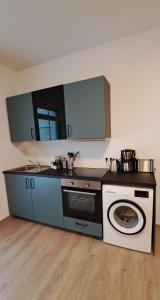 伊瑟隆Waldstadt-Apartments的厨房配有炉灶和洗衣机。