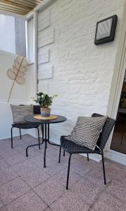 伊瑟隆Waldstadt-Apartments的庭院里设有两把椅子和一张桌子