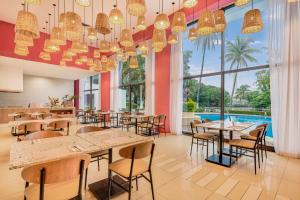 比亚埃尔莫萨比亚埃尔莫萨森卡里嘉年华酒店的餐厅设有桌椅和大窗户。