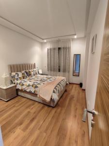 DerrouaLUXURY 3 bedroom apartment with pool, Nouaceur, Morocco的一间卧室配有一张床,铺有木地板