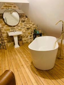 普卢加斯努Les chambres de sainte barbe的浴室配有白色浴缸和水槽