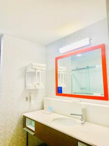 霍普港Hampton Inn by Hilton Port Hope Cobourg的一间带水槽和红色镜子的浴室