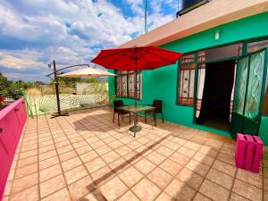 瓦哈卡市Hostal Mixteco Naba Nandoo的房屋内带桌子和遮阳伞的天井