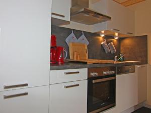 LütowApartment house, Lütow的厨房配有白色橱柜和炉灶。