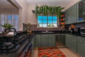 棕榈滩Villa Tamar的厨房配有灰色橱柜和窗户